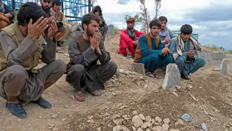 Getty Images Afghans pray at burial ceremony for blast victims - 18th August