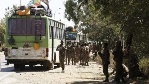 Getty Images Soldiers on patrol on Mekelle on a road with buses, Ethiopia - March 2021