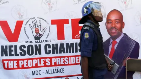 Reuters A riot police officer in front of an MDC Alliance poster in Harare, Zimbabwe