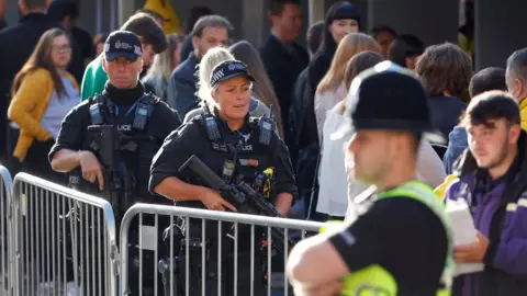 PA Armed police outside the arena