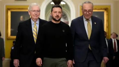 Getty Images Volodymyr Zelensky walks with Mitch McConnell and Chuck Schumer as he arrives at the US Capitol