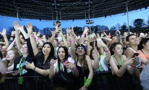 Getty Images Fans are pressed up against security barriers while attending a Billie Eilish concert in 2019
