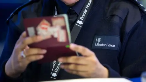 PA Border Force official checking passport