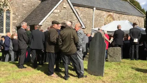 Funeral attendees outside church
