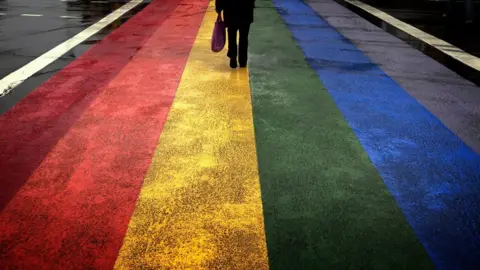 Reuters A figure walks along a rainbow painted road