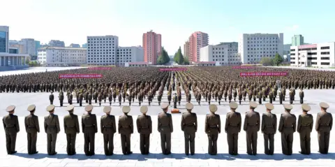 Getty Images Hundreds of people in neat rank-ad-file gather in a main square in Pyongyang for an anti-US rally, facing a straight line of men in military uniform, who are apparently inspecting the rally