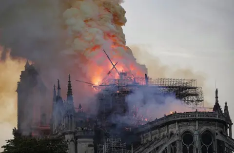 EPA The spire collapses while flames are burning the roof of the Notre-Dame Cathedral