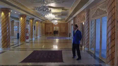 Getty Images March 7, 2018 shows a bellboy standing at a hall of the Intercontinental Hotel in Kabul.