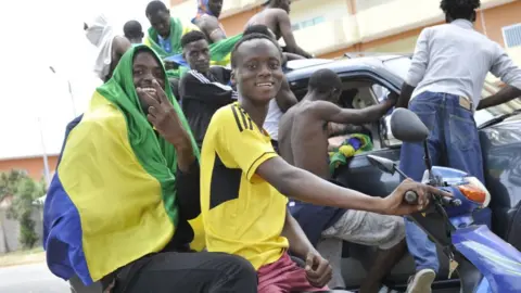 AFP Men on motorcycles holding Gabon flag, 30 August