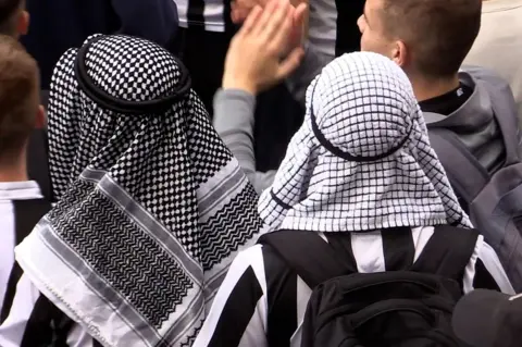 PA Media Two fans with Saudi headdress