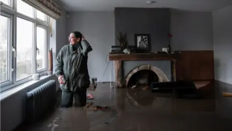 PA Media Gabrielle Burns-Smith in her flooded home