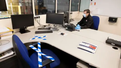 Getty Images A man in an office wearing PPE