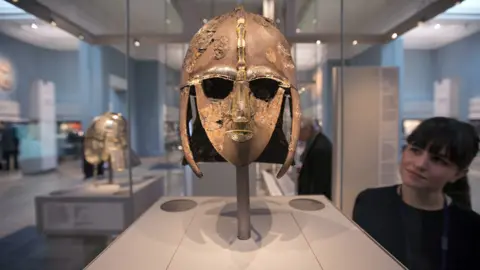 Getty Images A woman views the Sutton Hoo Helmet on display in the new gallery 'Sutton Hoo and Europe AD 300-1100' in the British Museum