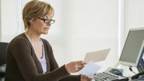 Getty Images Women looks at bills