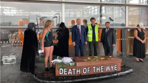 A group of campaigners outside the Welsh Parliament to protest about the amount of pollution in the River Wye.