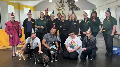 Dogs Trust Ty with his owners and Dogs Trust volunteers