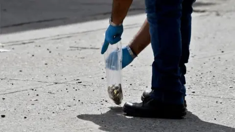 AFP Forensics officer gathering evidence in the Mexican city of Culiacan the day after cartel members went on the rampage, 18 October 2019