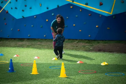 Macarena Norambuena  A child runs towards a woman at the playground created by Deporte Libre