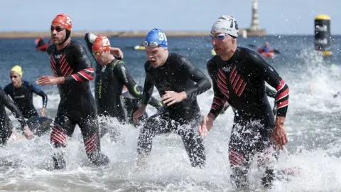 PA Media Athletes taking part in the swim leg of the triathlon at Sunderland last month