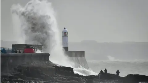 PA A wave slaps against the harbour wall at Porthcawl, Wales