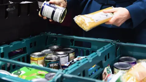 PA Media Food bank staff preparing food parcels