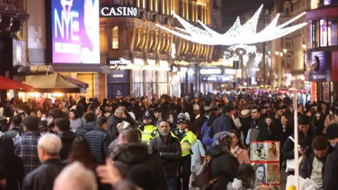 PA Media People gather in large numbers in Leicester Square, central London