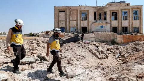 Getty Images Members of the Syrian Civil Defence, also known as the White Helmets, in the western countryside of Syria's northern Aleppo province, 31 August 2019