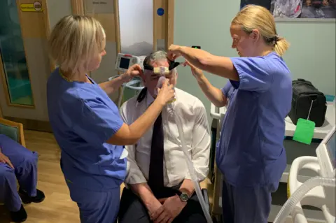 John Wright Alex Brown acting as a dummy for medical staff learning to use a CPAP ventilator