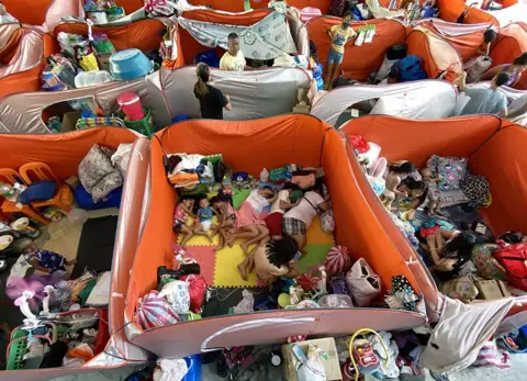 Francis R Malasig / EPA Homeless families rest inside a gymnasium