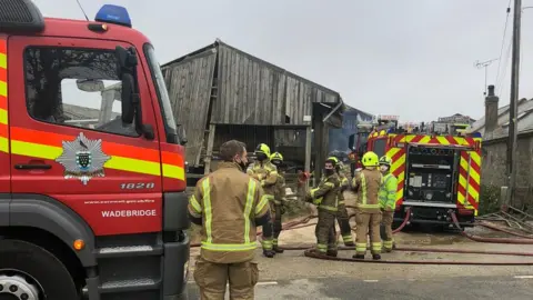 Firefighters outside burnt barn