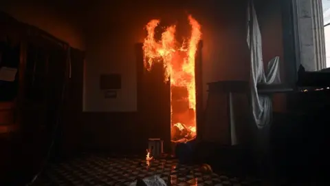 Getty Images Vista de una oficina en el edificio del Congreso incendiada por manifestantes que exigían la renuncia del presidente Alejandro Giammattei, en la Ciudad de Guatemala el 21 de noviembre de 2020.