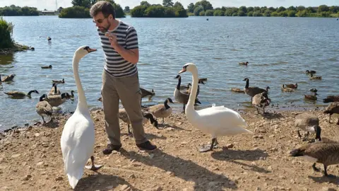 Getty Images Visitor feeding birds at reserve