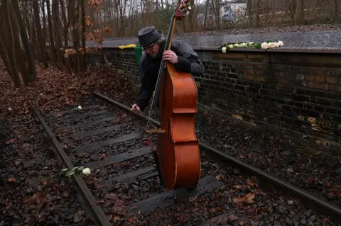 Sean Gallup / Getty Images Musician Carmelo Leotta plays an improvisational piece on a contrabass at the Gleis 17 memorial in Berlin to mark Holocaust Memorial Day on 27 January 2023