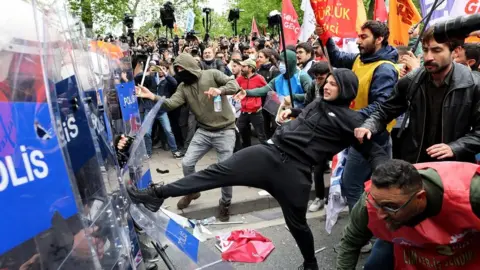 Protesters clash with riot police as they attempt to reach Taksim Square to celebrate the International Labor Day in Istanbul, Turkey. One protester is seen kicking a riot shield held by a member of the police cordon.