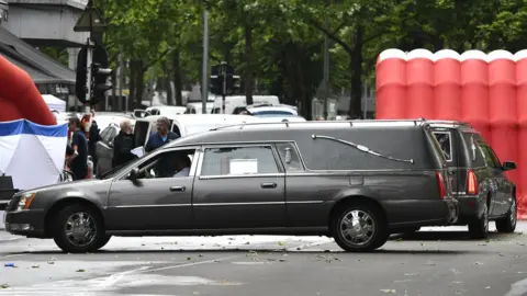 Getty Images Politieauto's geparkeerd nabij een politietent op de plaats van een incident waarbij een schutter twee politieagenten en een plaatselijke bewoner doodschoot in de Oost-Belgische stad Luik, 29 mei 2018