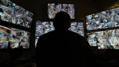 Filco's new CCTV system comprising of lots of screens with a silhouette of a person sat in front of them