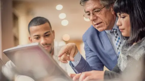 Getty Images Business people looking at laptop