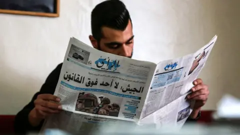 A Jordanian man reads a local newspaper in the capital Amman, April 2021