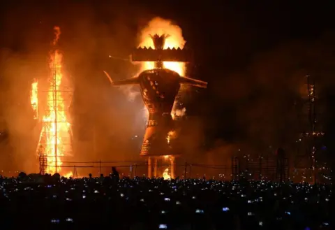 Getty Images Hindu devotees watch an effigy of the demon king, Ravana, stuffed with firecrackers, burning in Amritsar on 19 October 2018 on the occasion of the Hindu festival of Dussehra.