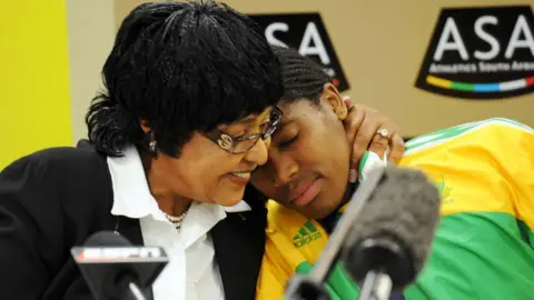 Getty Images Winnie Mandela and Caster Semenya talk to press during the Team SA Press Conference at the Holiday Inn on August 25, 2009 in Johannesburg, South Africa