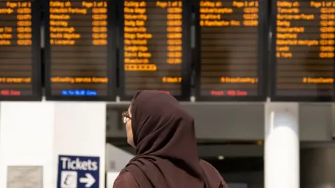 Getty Images Passengers interact with timetables inside a quiet Grand Central / New Street station