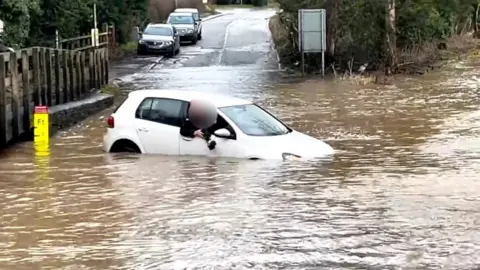 A car stuck in the Rufford Lane ford in Nottinghamshire