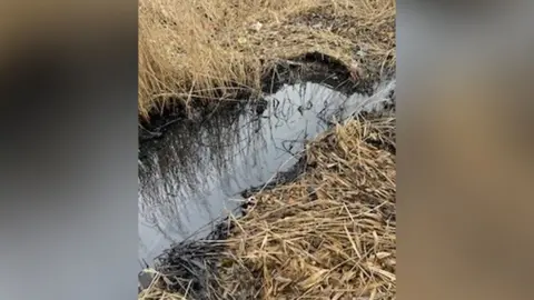 North Northamptonshire Council Culvert with grass either side showing black discolouration to water