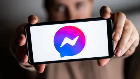 Getty Images A phone being held with the Facebook Messenger logo on it