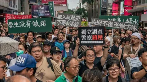 Getty Images Protesters hold placards and shout slogans as they take part in a rally on a street on July 7, 2019 in Hong Kong