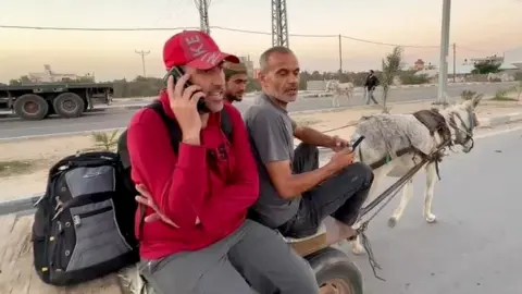 BBC Ahmed Sabra (L) and Abdalrahman Alharazin (R), British citizens who were prevented from leaving Gaza via Egypt, sit on a donkey cart near the Rafah border crossing (8 November 2023)