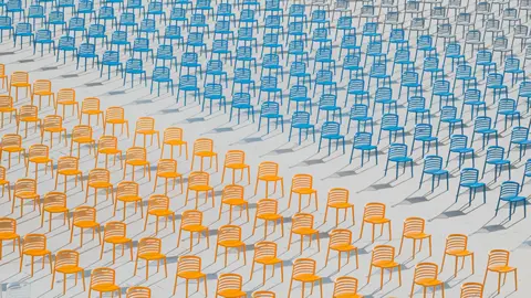 Hai Wang Rows of deserted brightly coloured empty chairs at a school