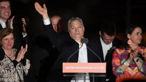 AFP/Getty Images Hungarian Prime Minister Viktor Orban (C) and members of his FIDESZ party celebrate winning the election