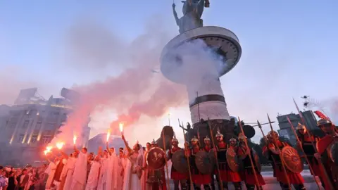 Getty Images Macedonians in costume stand in front of the 14,5 metre tall monument Warrior on a Horse on a 10 metre tall pedestal that is officially inaugurated in the centre of Skopje, the capital of the Republic of Macedonia, on 8 September 2011