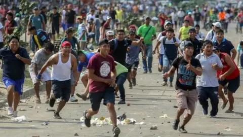 AFP Supporters of Bolivian opposition candidate Carlos Mesa and of president Evo Morales clash over disputed poll results, in Santa Cruz, Bolivia, on October 23, 2019.